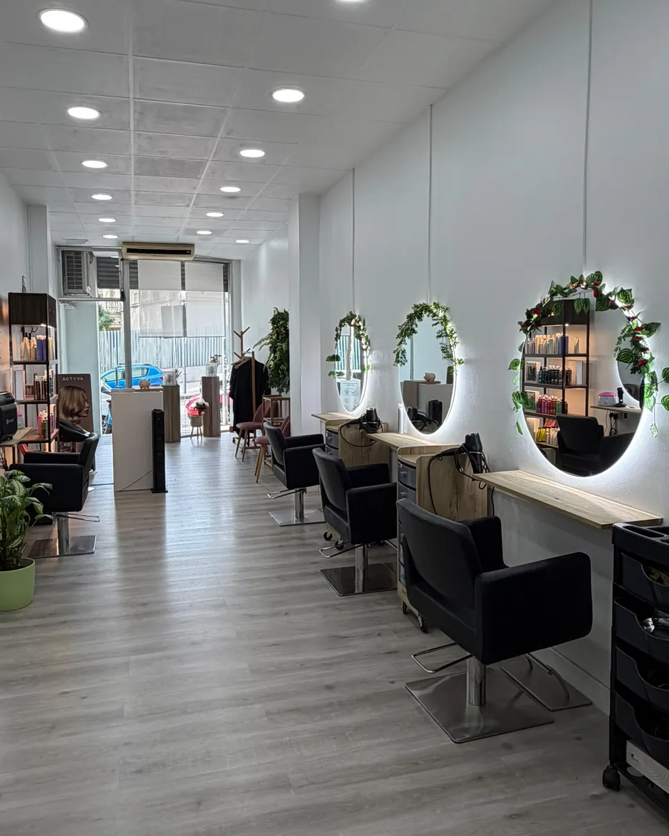 Pasillo del sal&oacute;n con los espejos redondos con guirnalda y los sillones negros