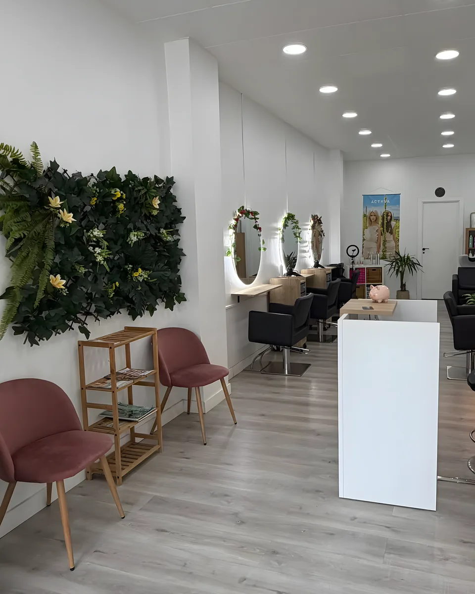 Zona de espera con la pared de plantas y las sillas de terciopelo rosa